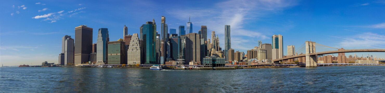 City skyline of New York City with Manhattan midtown business district office buildings near Brooklyn Bridge in panoramic view