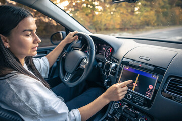 Woman using navigation system while driving a car.