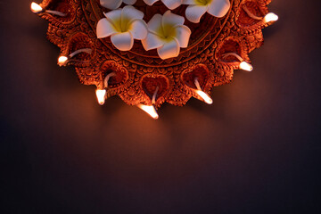 Happy Diwali concept background with traditional Diya lamp lit isolated on dark background, Hindu pooja concept image