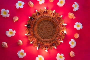 Happy Diwali 2024 concept image, Beautiful traditional Diya lamp with flowers on he background
