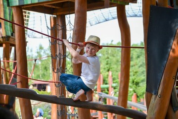 Fototapeta premium life of children in a modern city - little boy is having fun on the playground near the house