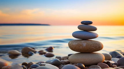 Fotobehang stack of zen stones on the beach, sunset and ocean in the background © Natalia Klenova