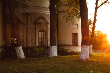 The wall of the old church. The old church in the rays of the setting sun. An old house in the park.