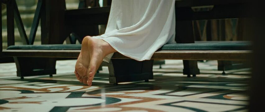 Parishioner prays to God on her knees. Maundy Thursday before Easter. Commemoration of the Last Supper. Barefoot woman in Christian Church.