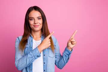 Image of happy young lady standing isolated over pink color background. Looking camera pointing