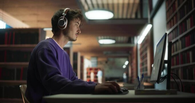 Portrait of a Handsome Student Creating a Business Research Presentation on a Desktop Computer. Young Stylish Male Studying in an University Library with Other People in the Background