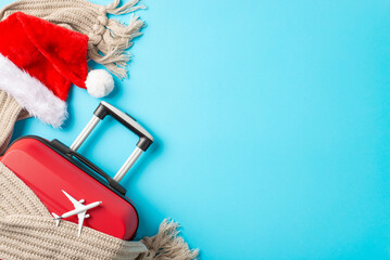 Santa's Airborne Trip: Overhead composition featuring a red suitcase, small plane model, Santa's...