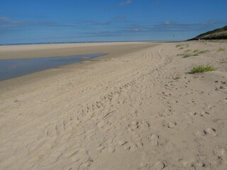 Tranquil beach scene featuring a sandy shore and blue sky. Spiekeroog, Germany.