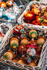 Fototapeta premium Winter holiday shopping. Christmas market with colorful holiday vintage Christmas toys and souvenirs in the wicked basket.