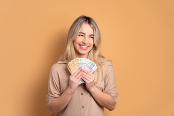 cheerful brazilian woman with money, brazilian real in studio shot. finance, investment, offer,...