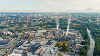 Fototapeta na wymiar Ghent, Belgium. Factory with chimneys and clouds of smoke in the suburbs of Ghent. River Esco (Scheldt), Aerial View