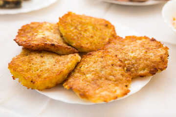Potato pancakes with sour cream on white plate