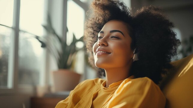 Happy afro american woman relaxing on the sofa at home - Smiling girl enjoying day off lying on the couch - Healthy life style, good vibes people and new home concept photography