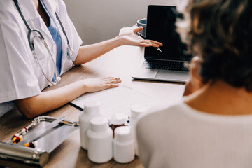 Smiling female doctor talking with senior patient in clinic office