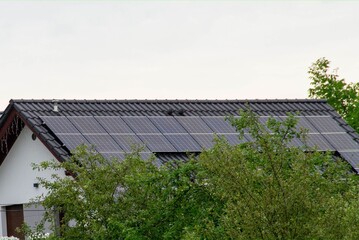 Historic farm house with modern solar panels on roof and wall
