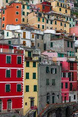Fototapeta na wymiar Village with narrow streets lined with brightly painted red and yellow houses in Riomaggiore, Italy