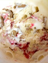 Close up of white and red ice cream, ice cream with strawberries jam and chocolate, macro, closeup