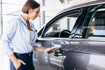 Woman standing by her new car and holding car keys