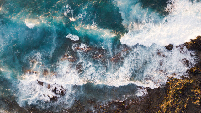 Atlantic ocean with strong swell beating against the walls of a rocky cliff, blue rough sea with big waves with foam crashing against the rocks, south of Tenerife, Canary island