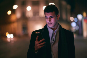 Smiling Meedle Eastern man walking down street near modern office building,