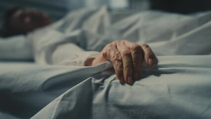 Close-up of terminally ill senior woman lying in bed, suffering from strong pain