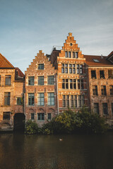 Last remnants of the evening sun illuminate historic buildings on the waterfront in downtown Ghent,...