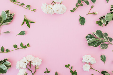 Roses flowers and green leaves on pink background. Flat lay, Top view