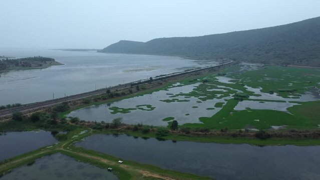 Aerial view of green rice paddies and moving train  in Puri, Odisha,india