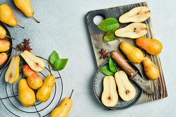 Pear. Sweet juicy pears in a plate and slices of pears top view. Gray table. Autumn fruits.