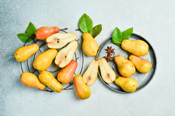 fresh pears with leaves on gray table. Autumn fruits. Top review.