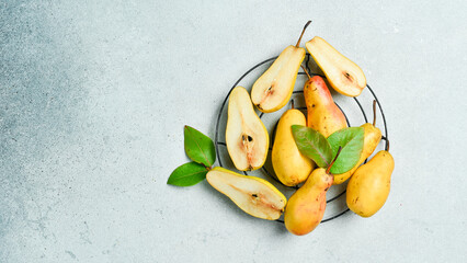 fresh pears with leaves on gray table. Autumn fruits. Top review.