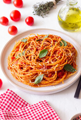 Spaghetti pasta with tomato sauce, basil and Parmesan cheese. Italian cuisine. Vegetarian food.