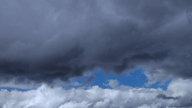 Unprecedented landscape of a huge black cloud and a cumulonimbus of the opposite color circulate in unison across the sky