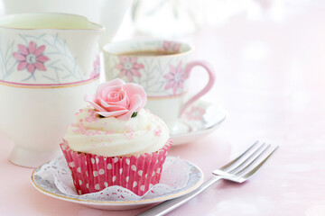 Obraz na płótnie Canvas Afternoon tea with a rose cupcake