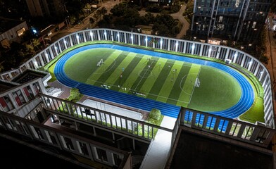 Aerial view of an illuminated soccer field on a tall building roof