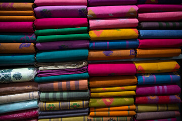 Artistic variety shade tone colors Saree's stacked on retail Shop Shelf to sale