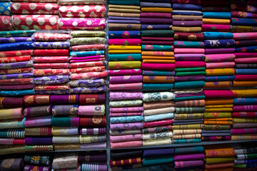 Artistic variety shade tone colors Saree's stacked on retail Shop Shelf to sale