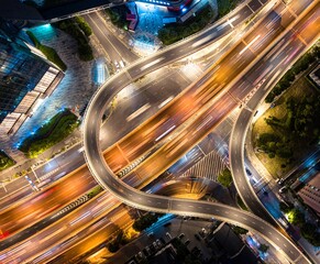 an overhead shot of an intersection at night time with many cars driving and traffic