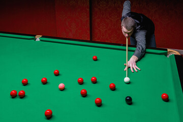 A skilled snooker player engaged in a captivating game of precision and strategy.
