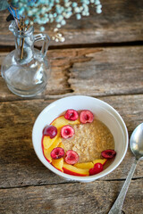 Oatmeal with nectarines and cherries. wooden background, side view. healthy breakfast cereal.