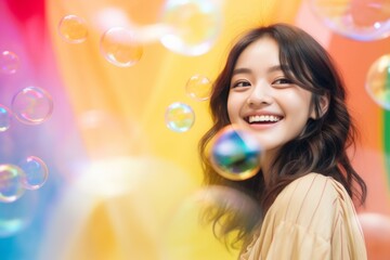 happy smiling asian woman on colorful background with rainbow soap balloon with gradient
