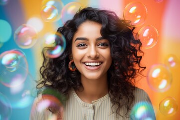 happy smiling indian woman on colorful background with rainbow soap balloon with gradient