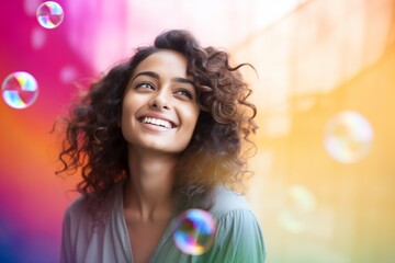 happy smiling indian woman on colorful background with rainbow soap balloon with gradient
