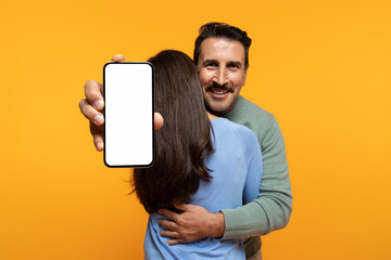 Smiling old european man hug woman show smartphone, with blank screen - obrazy, fototapety, plakaty
