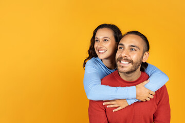 Obraz premium Cheerful young lovers embracing and looking at copy space