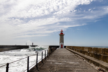 Felgueiras Lighthouse in Porto on the Atlantic coast with huge waves in a sunny day, splashing waves at Farol de Felgueiras