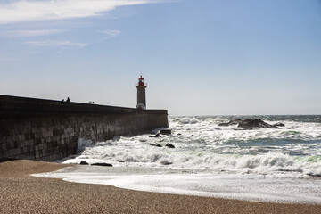 Felgueiras Lighthouse in Porto on the Atlantic coast with huge waves in a sunny day, splashing waves at Farol de Felgueiras