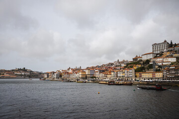 Fototapeta na wymiar Panoramic view of Porto with Duoro river on a cloudy day, Porto cityscape with boats