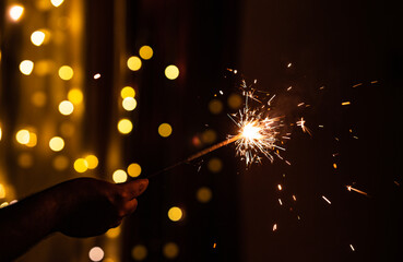 Hand holding sparkler and celebrating Diwali festival, Happy Diwali concept background