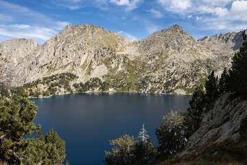 Fototapeta na wymiar Beautiful landscape of Black lake (Estany negre) in the natural park of Aigestortes y Estany de Sant Maurici, Pyrenees valley with river and lake